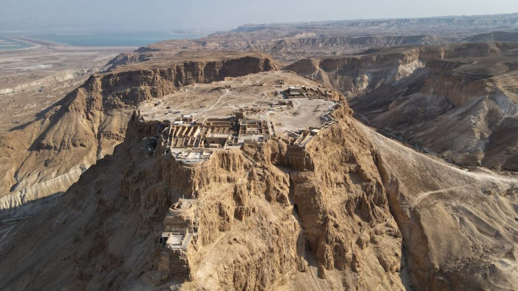 Aerial view of Masada with the remains of the ancient Roman siege ramp visible on the right.