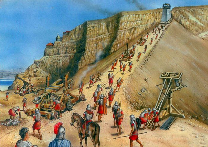 Roman soldiers in traditional clothing climbing the ramp to the ancient fortress of Masada, with a siege machine visible at the top.